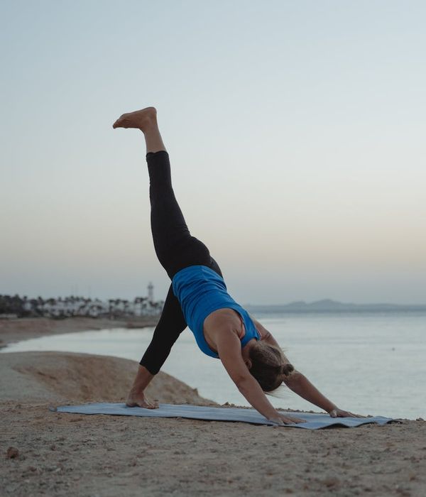 Woman in a peaceful yoga pose against a calm background.